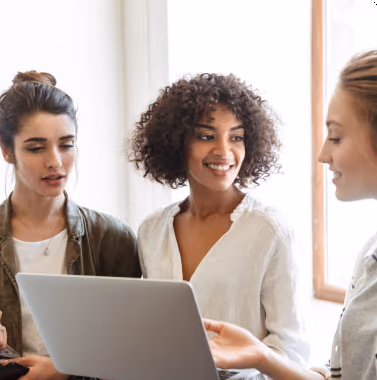 Three women looking at a laptop together