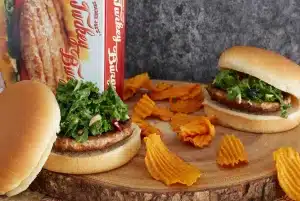 Turkey Burgers on a wooden table with chips on the side