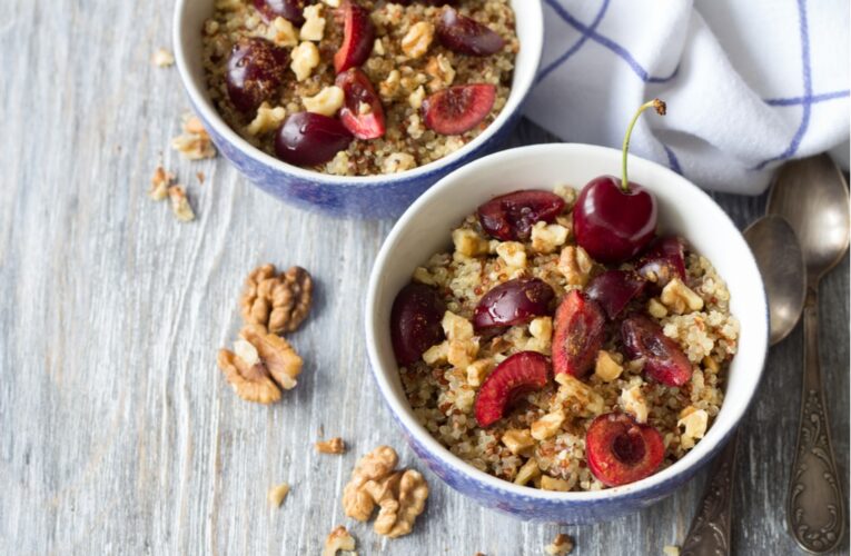 Bowl of better-than-cereal grain bowl with cherries on a table