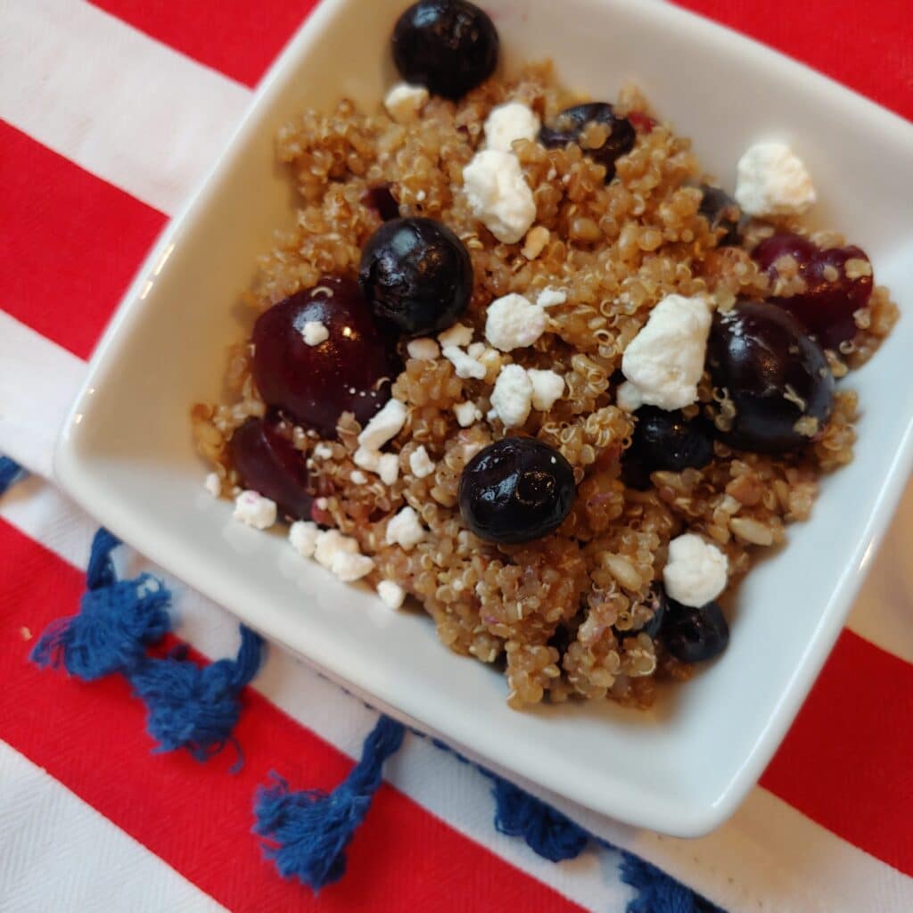 Summer quinoa salad in a bowl with blueberries.
