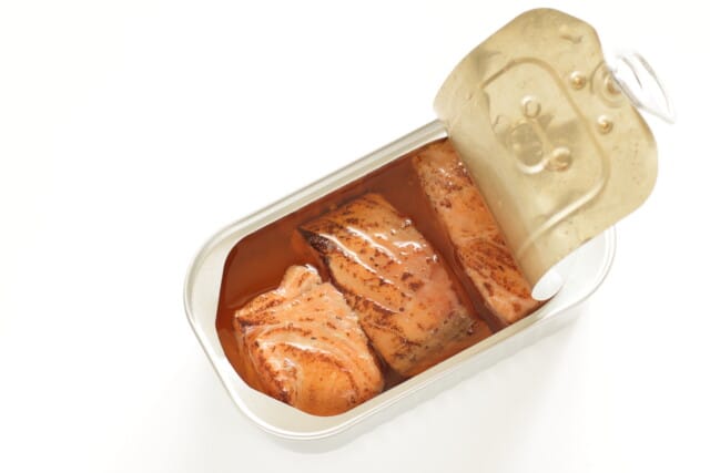 Opened canned grilled salmon on a white background