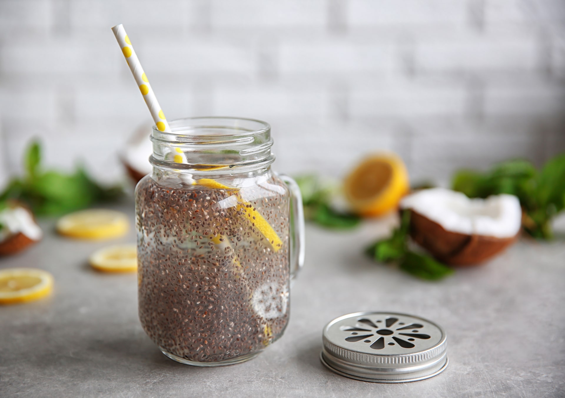 Chia seeds drink with lemon and mint in glass jar on table