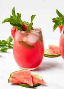 Watermelon mocktail in a glass with sliced watermelon on the side